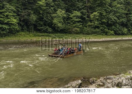 Wooden boats with passengers on Dunajec river in cold summer day