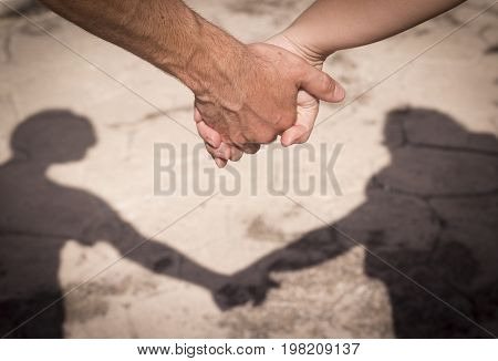 Hands of two lovers intertwined. Silohuette of a lovers.