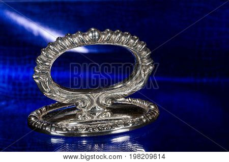 Ornate Antique Silver Paperweight Resting on a Blue Surface