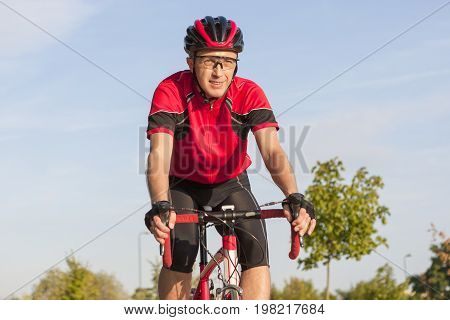 Cycling Concepts. Smiling Caucasian Road Cyclist During Ride on Bike Outdoors. Completely Equipped in Professional Outfit.Horizontal Image Composition