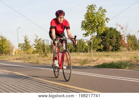 Sport and Cycling Concepts. Professional Male Cyclist in Racing Outfit During a Ride on Bike Outdoors. Horizontal Image Composition