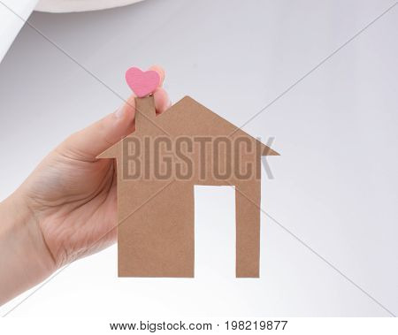 Hand Holding A Paper House On Canvas