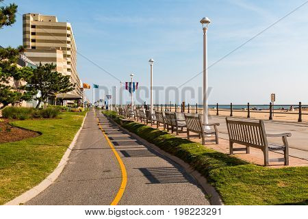 VIRGINIA BEACH, VIRGINIA - JULY 13, 2017:  The oceanfront boardwalk for pedestrians with a parallel paved path for bikes and surreys.