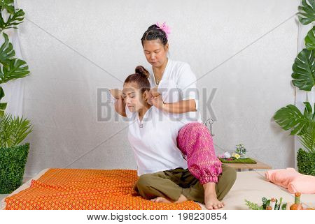 Asian Woman Getting Traditional Thai Stretching Massage By Therapist