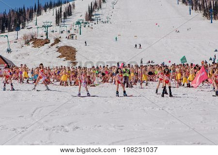 Group Of Young Happy Pretty Women On A Snowboard In Colorful Bikini With Flags.