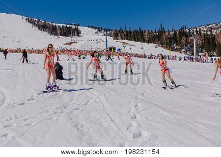 Sheregesh, Kemerovo region, Russia - April 22, 2017: Grelka Fest is a sports and entertainment activity for ski and snowboard riders in bikini. Group of young women on a snowboard in colorful bikini.