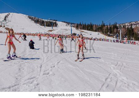 Sheregesh, Kemerovo region, Russia - April 22, 2017: Grelka Fest is a sports and entertainment activity for ski and snowboard riders in bikini. Group of young women on a snowboard in colorful bikini.