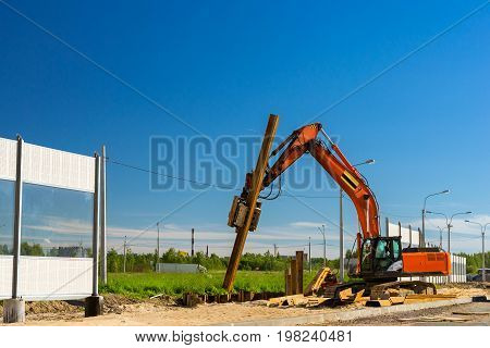 Crawler Excavator to hammer a steel piles into ground. Construction of high-speed bypass road around Krasnoe Selo Saint Petersburg. Heavy machine equipment for excavation works in industry. Russia
