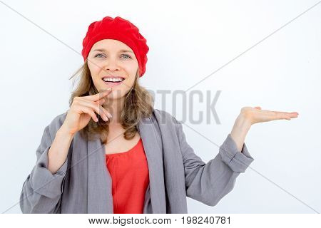Happy pensive woman demonstrating good product and looking at camera. Cheerful young French woman promoting item. Presentation concept