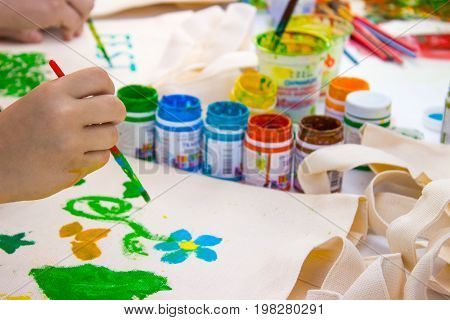Brush in the children's hand that draws a water colors