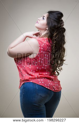 Plus size fashion model in casual clothes fat woman on beige studio background overweight female body