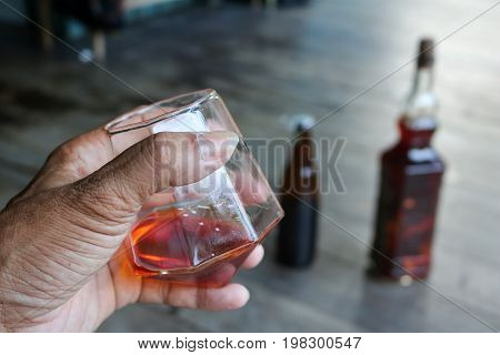 Local whiskey in a glass with bottle of herbal liquor in Thailand.