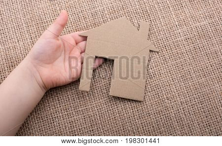 Hand Holding A Aper House On A Canvas Background