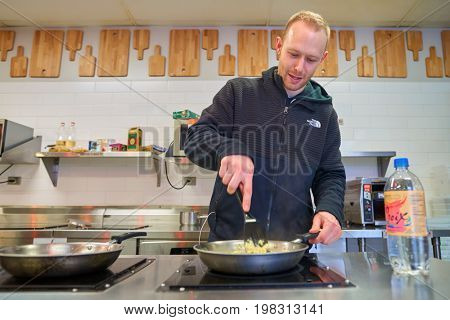CHICAGO, IL, - CIRCA APRIL, 2016: man prepare food at Chicago Getaway Hostel. Hostels provide budget-oriented, sociable accommodation where guests can rent a bed, usually a bunk bed, in a dormitory.