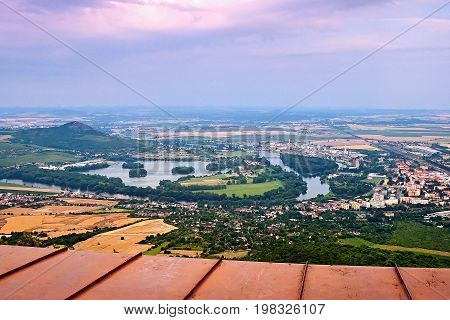 View from Lovos hill to european river Labe in Lovosice city and Pistany lake under Radobyl hill in PLA Czech central mountains at sunset
