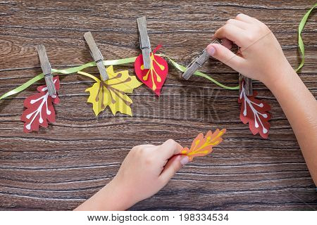 Autumn Background With Colorful Different Leaves Of Paper And Wooden Clothespins On A Wooden Backgro