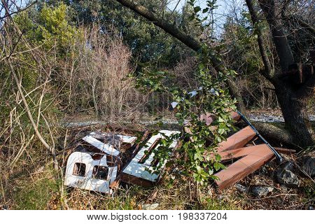 Old big letters of a sign store abandoned on grass