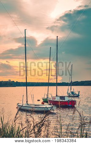 Summer evening landscape. Boats on the lake and colorful sky.