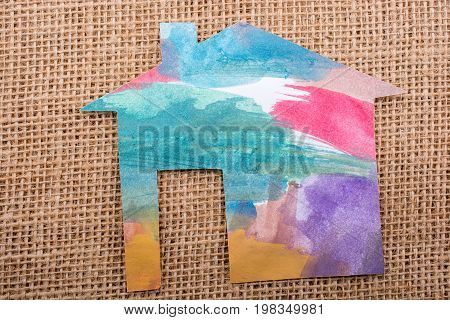 Hand Holding A Paper House On Canvas