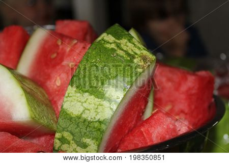 Bowl of bright red and  green watermelon in a picnic.