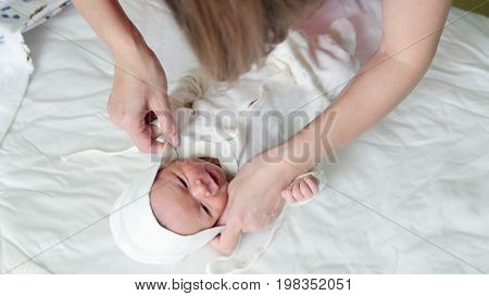 Mother is swaddling her child - newborn baby infant, close up