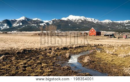 A ranch farm homestead looks cold and bright during winter frost