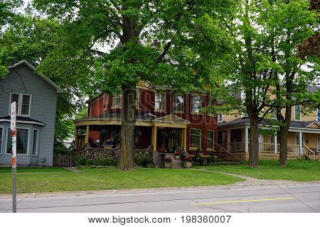 CADILLAC, MICHIGAN / UNITED STATES -  MAY 31, 2017: A red brick home with a wraparound porch in Cadillac's Courthouse Hill Historic District.