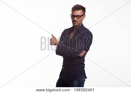 Young jocular man portrait of a confident businessman showing by hands on a gray background. Ideal for banners, registration forms, presentation, landings, presenting concept.