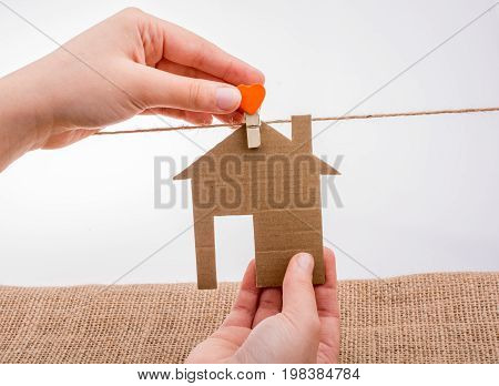 Hand holding a aper house on a canvas background