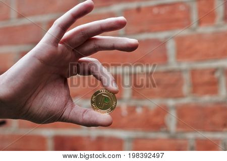 Gold Peercoin Coin In Hand.