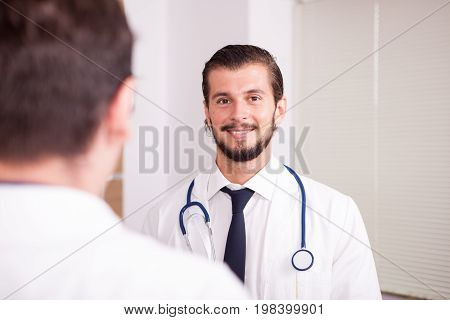 Two doctors in front of eatch other in hospital recovery room talking. Medicine and healthcare
