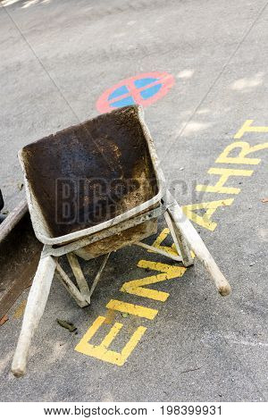 wheelbarrow with construction waste with street signs in german