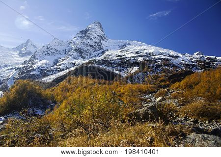 Mountains autumn landscape high peaks scenery wild nature calm scene. Lifestyle active travel hiking. Scenic scenery of wild snowy mountains and alpine valleys.