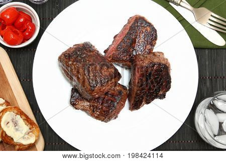 Steak, Low Carb Bread, Peppadew Peppers at table with glass of water. 