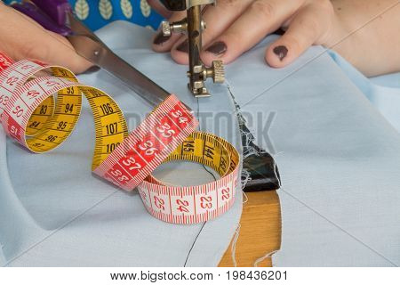 closeup of woman hands sewing yellow cloth outdoors. Woman's Hand Sewing Quilt