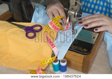 closeup of woman hands sewing yellow cloth outdoors. Woman's Hand Sewing Quilt