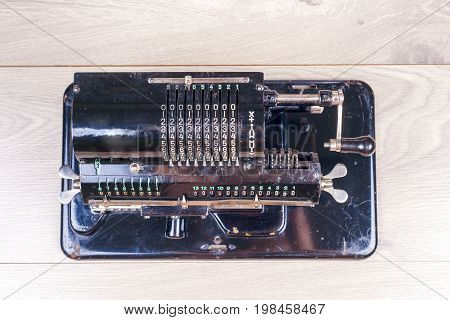 Old Rusty Retro Calculator Black Standing On A Wooden Table