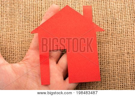 Hand Holding A Paper House On Canvas