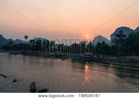 The colorful sunset over Nam Song River with hot air ballon in Vang Vieng Laos.
