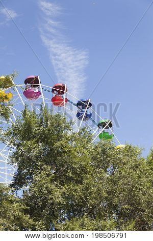 The big wheel in the park joyfully turns rolling vacationers