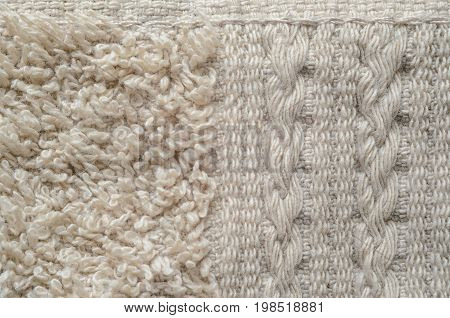 A macro shot of an element of beige color towel. Fleecy part and decorative element with braided pigtails. Texture is similar to the texture of a fleecy knotted-pile carpet.