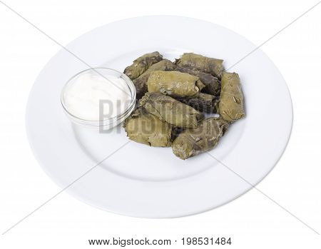 Stuffed grape leaves with sour cream.   Isolated on a white background.