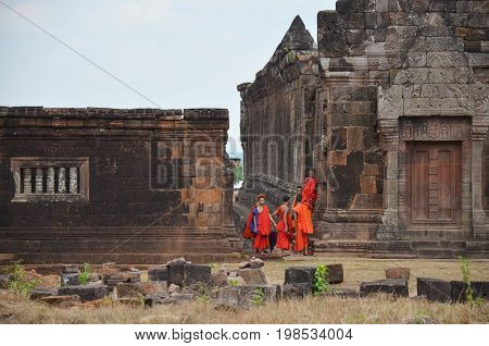 Laotian Monk And Novice Visit With Pray Buddha And God Statue At Vat Phou Or Wat Phu