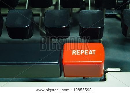Red repeat button on typewriter. Do something again.