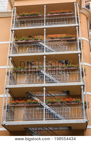 Fire Exit. Metal fire escape outside ladder on modern apartment building for emergency. Fire stairs on the building. A staircase on the external wall of an urban building.