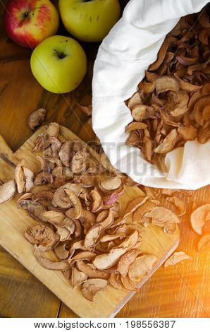 Dried and fresh apples at cutting board and cloth bag. Rustic vintage style. Countryside