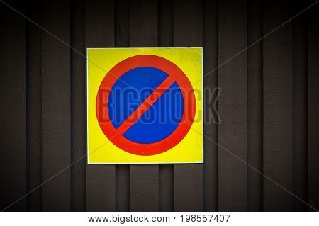 No parking sign. Prohibition symbol. Sign indicating warning and forbidden. Grunge shabby paper sticker isolated on dark wooden background.