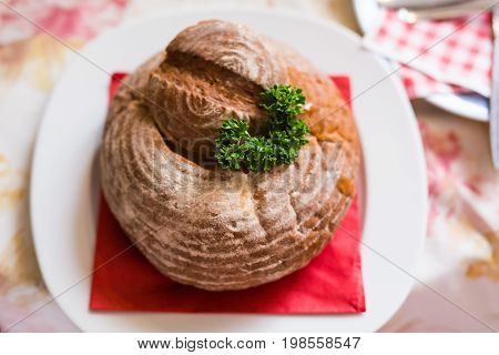 Goulash soup in bread served in a bread bowl.