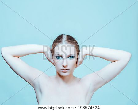 Attractive blonde naked woman with dark eye make up.
