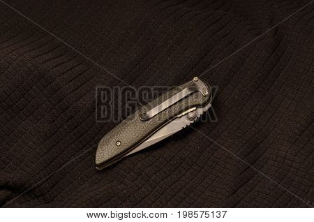 Black Knife Folded On A Black Background. Back Side.
